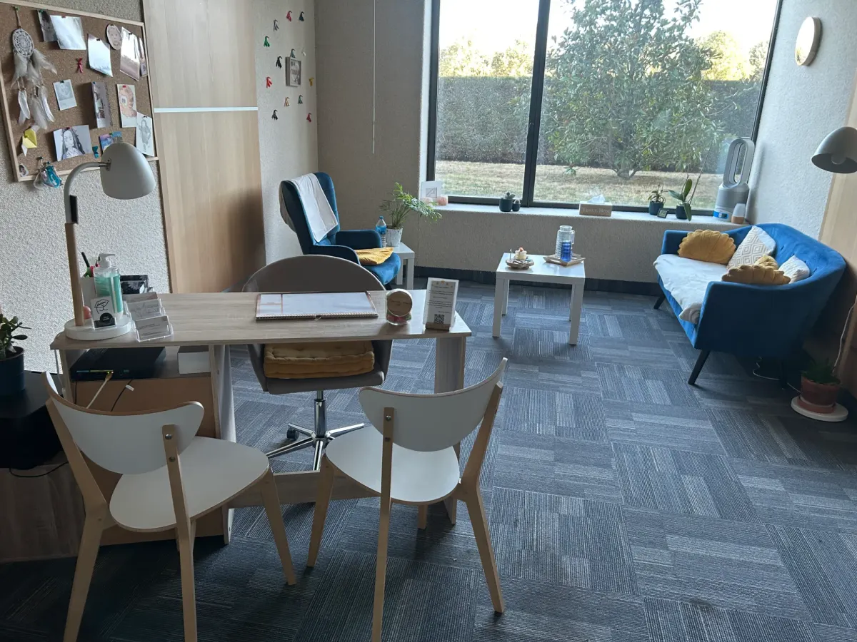 Vue du cabinet avec le bureau au premier plan et le coin salon au fond